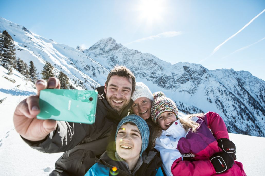 Winterurlaub Tirol. Selfie Familie im Schnee. Apart Peppone