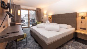 Doppelbett, TV Gerät Tisch und Stühle in Appartement, Ferienwohnung Tirol